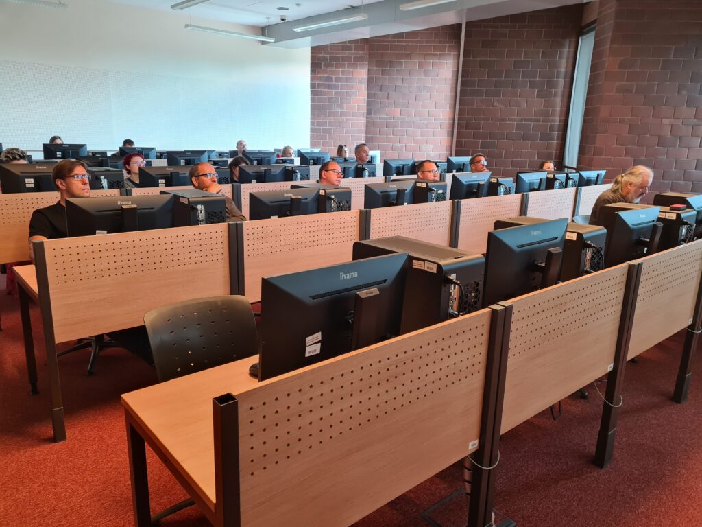 Uczestnicy szkolenia korzystają z komputerów podczas zajęć z analizy danych przestrzennych.