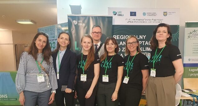Siedem osób pozuje na tle grafiki z napisem „Regionalny Plan Adaptacji do zmian klimatu" na 4. Forum Misji UE”.