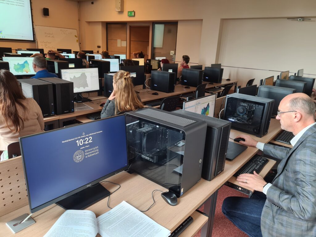Uczestnicy szkolenia korzystają z komputerów podczas zajęć z analizy danych przestrzennych.